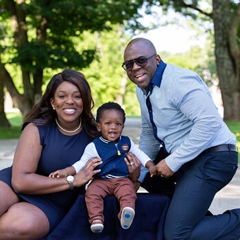 Our pediatric dentist in East Norriton, PA, Dr. Ngozi Okoh sitting with her husband and her baby in a park