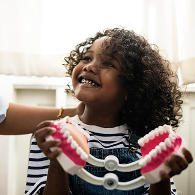 A girl in the office playing with some false teeth