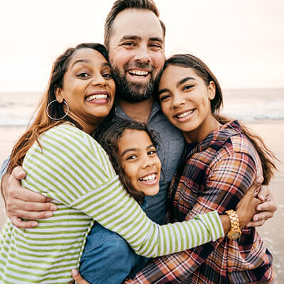 A family hugging on the beach